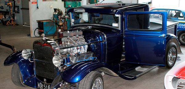 Blue hot rod with a supercharged V8 engine
